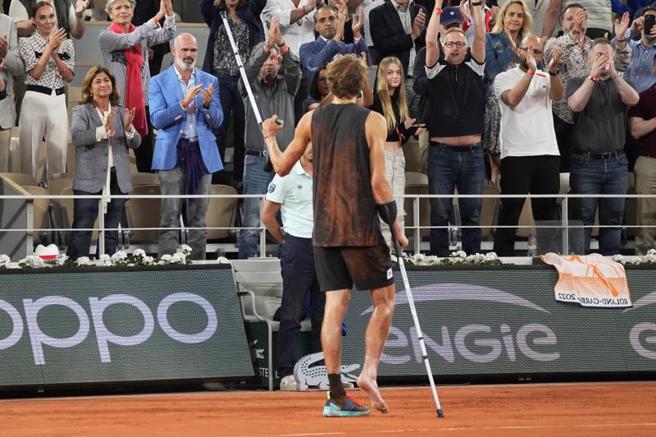 小祖维瑞夫严重扭伤右脚踝忍痛退赛，仍举起拐杖向中央球场的观眾致意。（美联社）