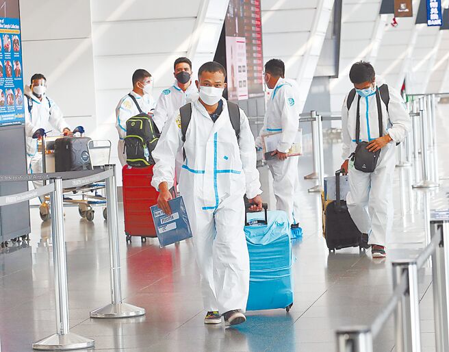 知名编剧岳清清15岁侄子染疫骤逝，他质疑政府规定只隔离7天是不是太轻敌？但指挥中心却拟再缩短现行7天入境检疫天数。图为桃园机场身穿防护衣的入境旅客准备离开机场。（范扬光摄）