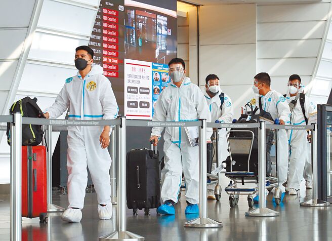 指挥官陈时中前日甩锅强调是24小时内通报，而非处理遗体。图为桃园机场第一航厦入境大厅内，身穿防护衣的旅客正准备离开机场。（范扬光摄）