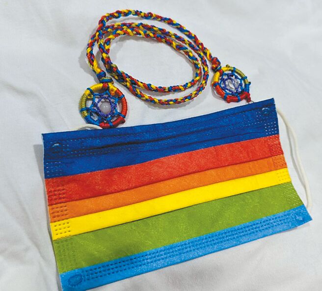 吉祥物工作室以虹色编织捕梦网串接于口罩，成为精致好看的口罩挂饰，定价600元。（吉祥物工作室提供）