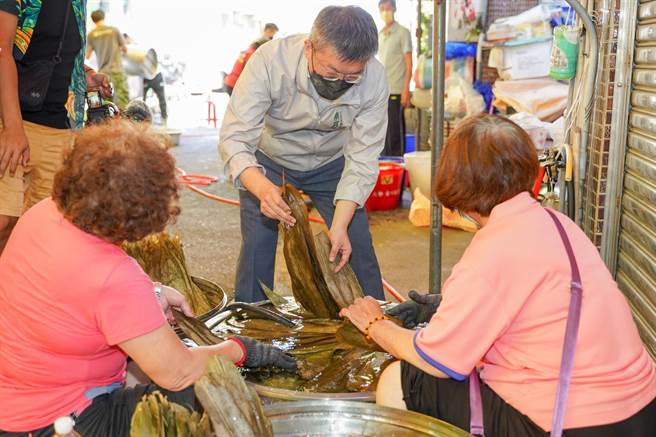 立法院副院長蔡其昌5日出席北勢愛心協會包粽子活動，挽袖和志工媽媽一起包粽子。（陳淑娥攝）