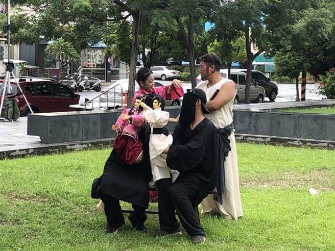 真云林阁布袋戏团的操偶师身穿黑衣，让戏偶走出戏棚与太日乐集的真人共演。（云林县府文化观光处提供）