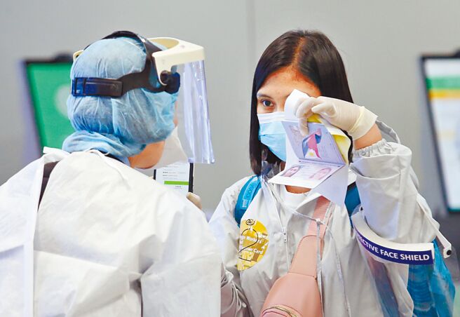 中央流行疫情指挥中心发言人庄人祥3日表示，指挥中心预计6月间公布边境松绑政策，将会缩短现行7天的入境检疫天数， 4日在桃园机场第一航厦入境管制区内，刚下机的旅客正在查验入境健康资料。（范扬光摄）