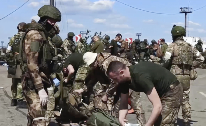 俄军正在对钢铁厂守军进行搜身。(资料照/俄罗斯国防部)  