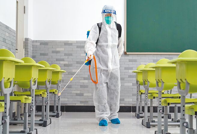 北京市除部分區域外，其他各區連續7天以上無社會面病例，6日起進一步分區分級動態放寬防疫限制。圖為工作人員在中國農業大學附屬中學的教室消毒。（新華社）