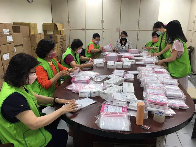 社會局局長謝琍琍(中、黑領白衣)與志工一起處理快篩劑發放。(高雄市政府社會局提供／林雅惠高雄傳真)