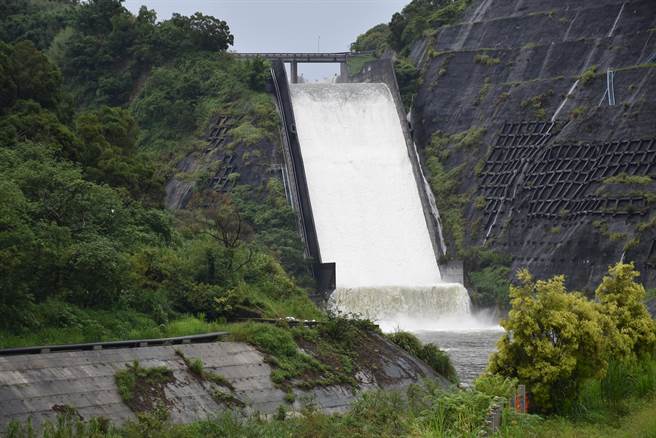 苗栗县连2日降下超大雨量，鲤鱼潭水库满水位自然溢流，彷如一片白练。（谢明俊摄）