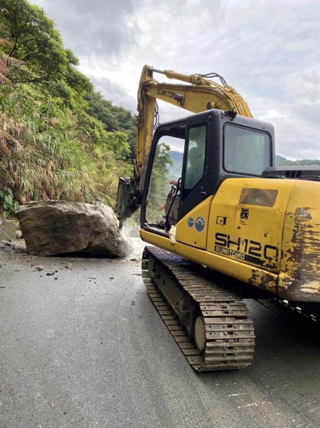  嘉義縣山區雨勢大，阿里山鄉達邦公路（169線）28公里處7日晚間又發生巨石掉落事件，幸無人員傷亡，8日上午現場以怪手進行落石清除作業。（圖/ 中央社）