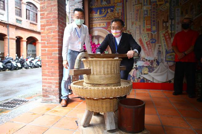 台北市新生老屋8日再增加大稻埕「稻舍」及「贝壳好室」，副市长蔡炳坤（左二）在稻舍体验碾米。（张立勋摄）