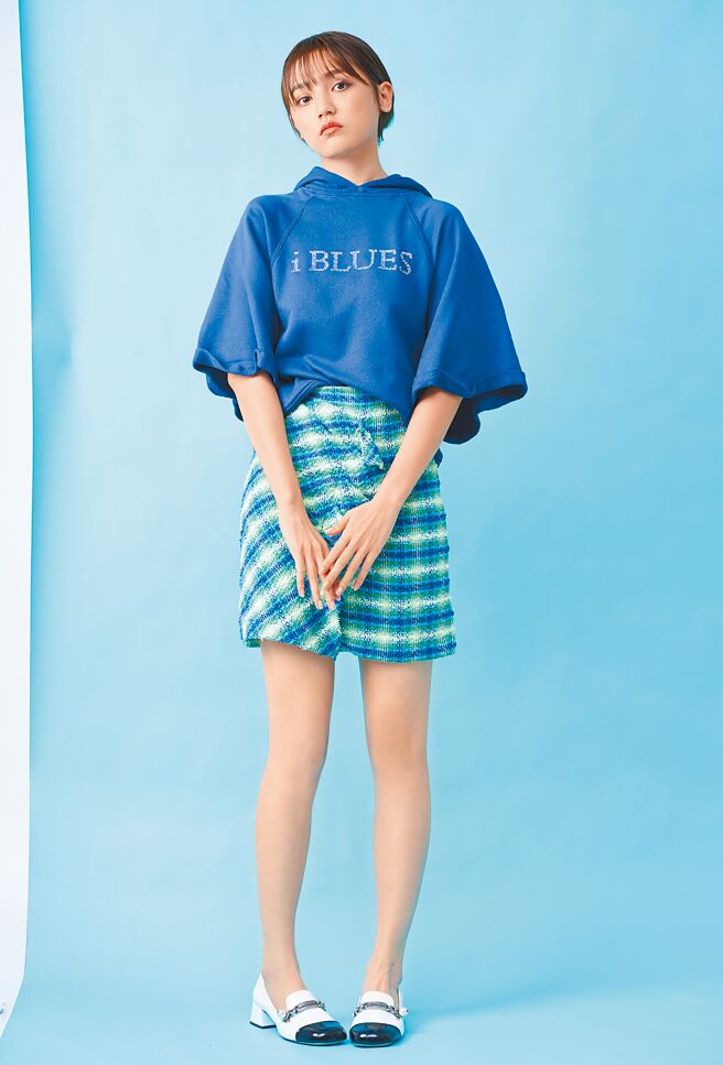 Dora俏皮与正经风格随时切换，热情能量让人更加好奇她不同的样貌，iBLUES的LOGO连帽衫9600元，渐层窗格呢料短裙8800元。（JOJ PHOTO摄）