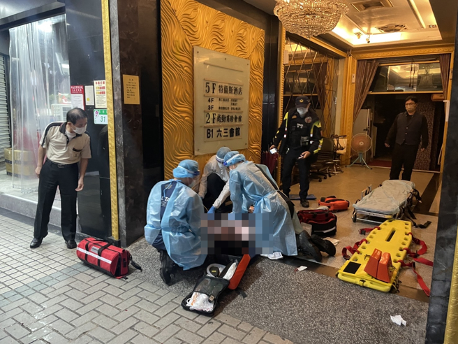 北市長春路及林森北路口一家酒店應晨發生鬥毆，1名男子遭3人圍毆狂砍，左胸中刀倒血泊無生命跡象，警方圍起封鎖線進行鑑識。(戴志揚翻攝)