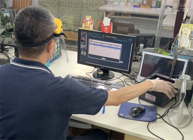 移民署高雄港隊查驗人員使用視訊鏡頭進行人證核對。（翻攝照片／高雄洪靖宜傳真）