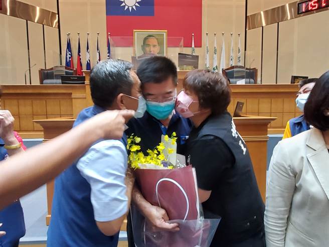 诚信党团议员王钰齐（右）及国民党团议员顏忠义（左）献吻。（周丽兰摄）