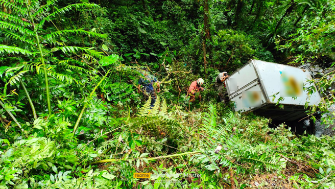 整輛貨車滑落溪谷下方約5公尺處。貨車意識清醒，警消正將車輛及傷者吊掛上山谷。(戴志揚翻攝)