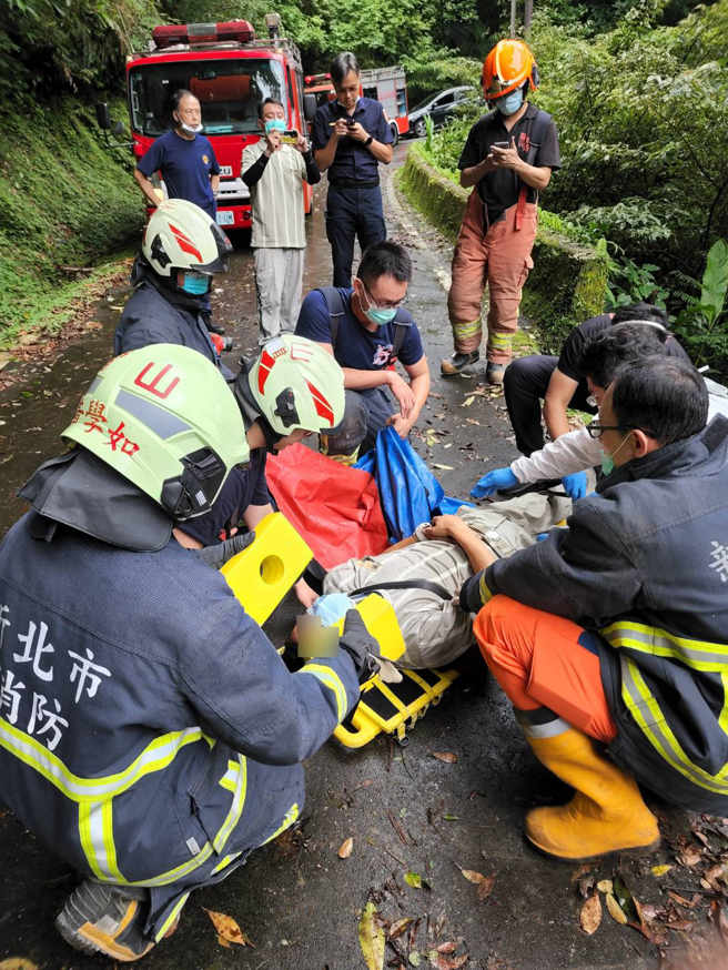 整輛貨車滑落溪谷下方約5公尺處。貨車意識清醒，警消正將車輛及傷者吊掛上山谷。(戴志揚翻攝)