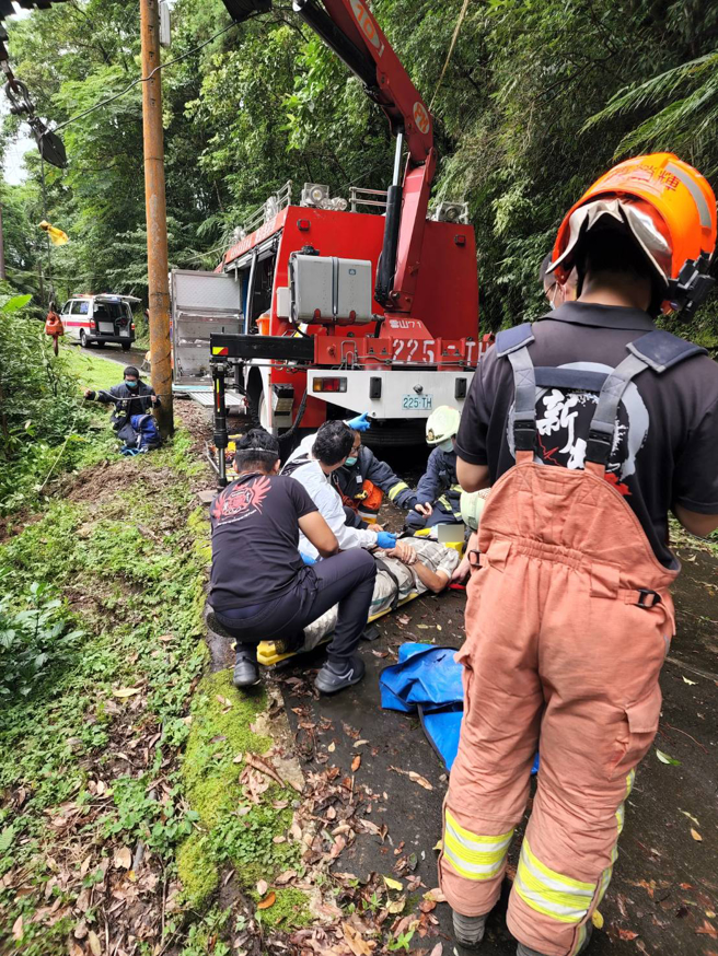 整輛貨車滑落溪谷下方約5公尺處。貨車意識清醒，警消正將車輛及傷者吊掛上山谷。(戴志揚翻攝)