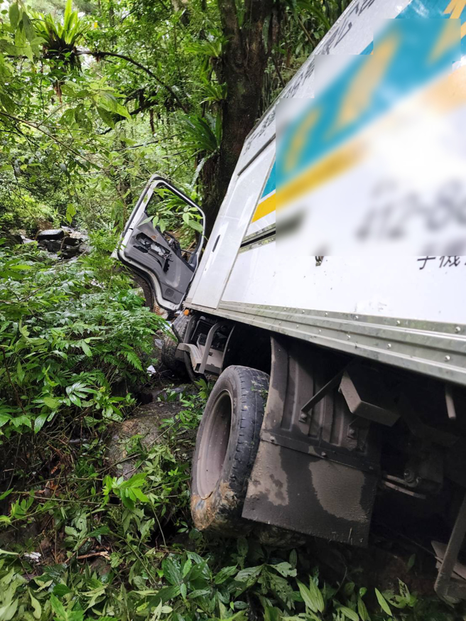 整輛貨車滑落溪谷下方約5公尺處。貨車意識清醒，警消正將車輛及傷者吊掛上山谷。(戴志揚翻攝)