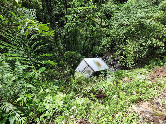 整輛貨車滑落溪谷下方約5公尺處。貨車意識清醒，警消正將車輛及傷者吊掛上山谷。(戴志揚翻攝)
