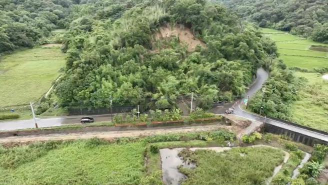 苗栗县造桥乡平兴村田园路山坡疑因连日大雨冲刷、土石松动，造成坍方走山，大片土石、树木滑落占据道路，县府採空拍进行勘灾作业。（图/ 中央社）