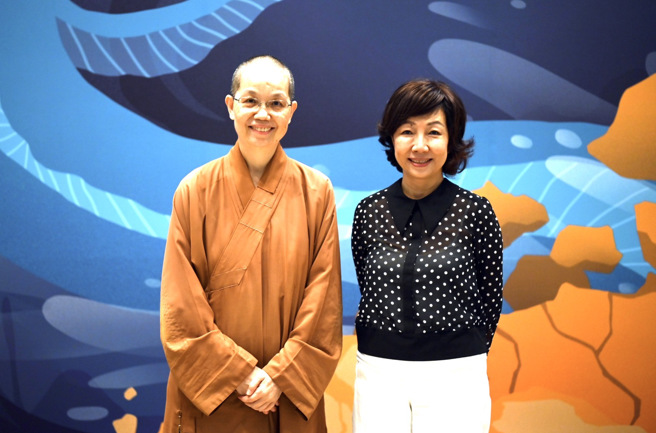 佛光山中区总住持觉居法师（左）与讲师丁菱娟（右）于未来与希望讲座主视觉看板前合影。(图/佛光山惠中寺提供)