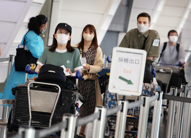 日本今起开放98个国家与地区观光旅游团入境。图为桃园机场第一航厦入境大厅内，刚下机的旅客准备搭车离去。（范扬光摄）