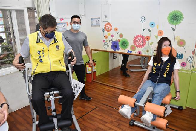 竹南镇长方进兴与镇代会主席何秀绵一同体验健身器材。（谢明俊摄）