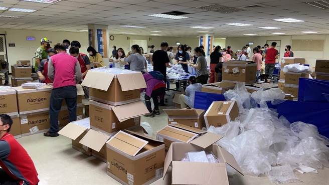 台中市议会民进党团接获陈情，指市府基层员工被迫投入快筛试剂分装作业，环保局地下室成为快筛试剂贴贴纸工厂。（图／江肇国服务处提供） 