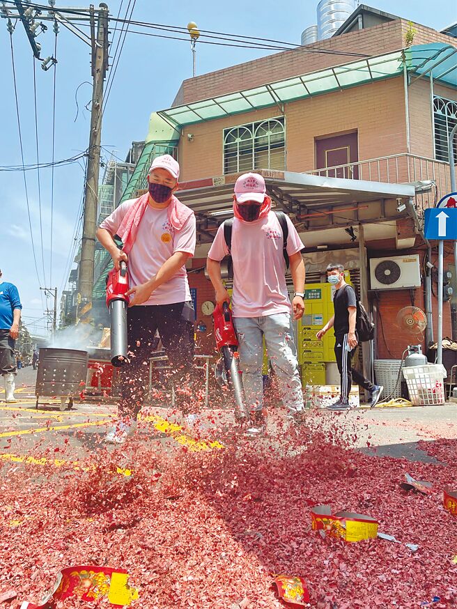 草爷（左）、超艾夹先用吹叶机集中鞭炮灰，再进行下一步清洁。（红心字会提供）