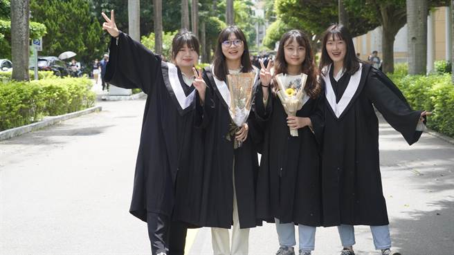 勤益科技大学于11日举办毕业典礼，因应防疫採缩小规模实体办理并同步线上直播，校方也在校园户外区设置纪念背板，毕业生与家长合照留念。（冯惠宜摄）