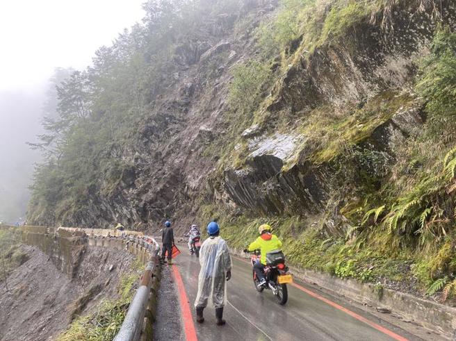 高雄山區11日午後雨勢不斷，南橫公路台20線臨105便道28.6公里處山壁有落石，甲仙工務段正派員清除，並宣布南橫天池至埡口路段禁止車輛通行；轄區六龜警方協助交通疏導管制，透過警廣宣導遊客非必要勿上山。（圖/ 中央社）