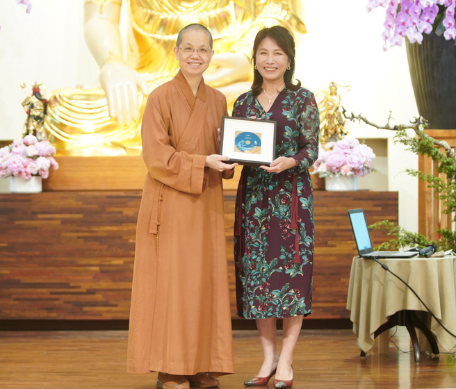 佛光山中區總住持覺居法師（左）贈送講師紀念光碟給王瑞芹老師（右）。(圖/佛光山惠中寺提供)