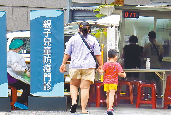 国内染疫死亡数平均13天就翻倍，高居全球第2快，在野党批评蔡政府先前压制病例数及死亡数，如今星火燎原。图为家长带着小朋友就诊。（姚志平摄）