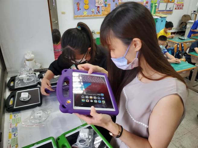 金门县各国小今日復课，图为柏村国小老师检收iPAD回充电车。（柏村国小提供）