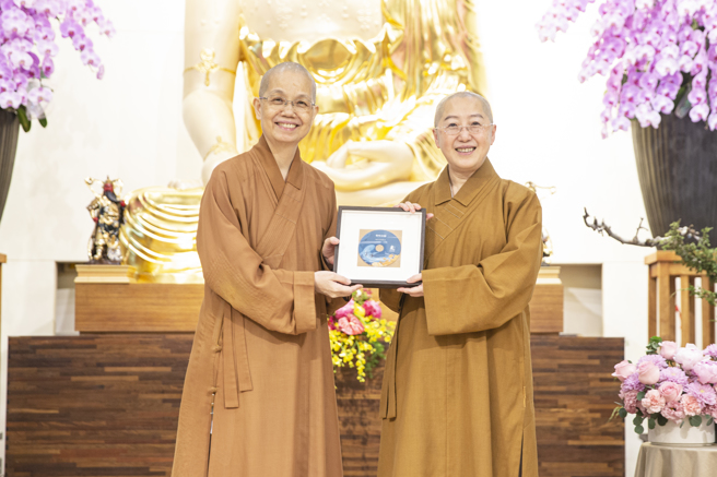 佛光山中区总住持觉居法师（左）致赠讲座纪念光碟予觉培法师（右）。(图/佛光山惠中寺提供)