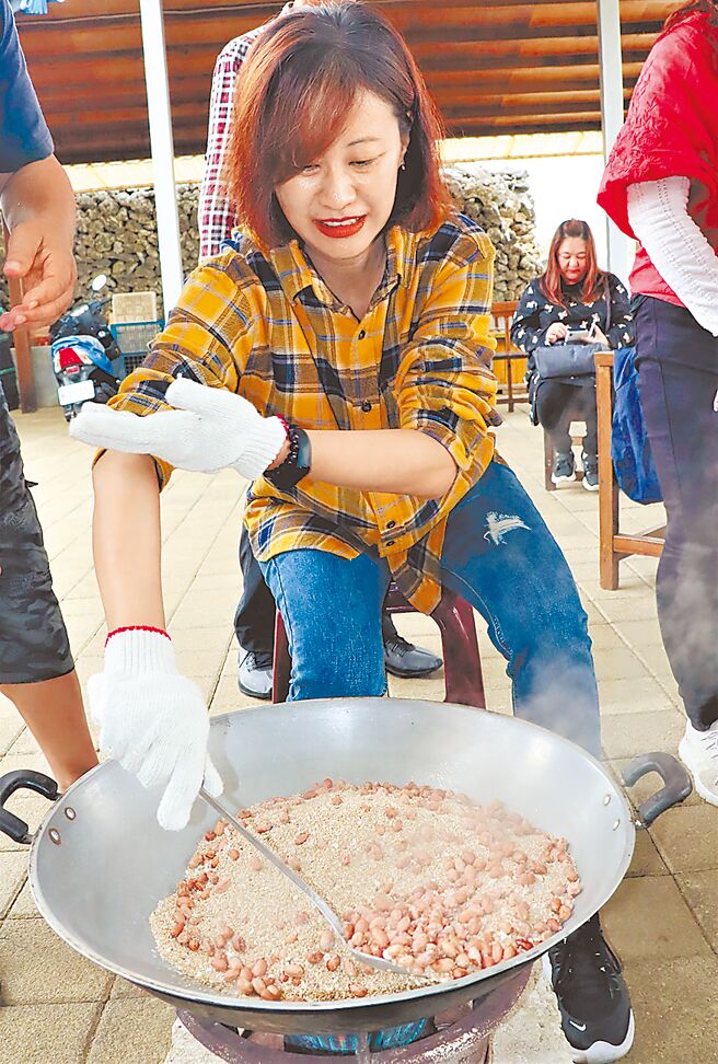 南寮风车有机农场搬出澎湖先民的拿手绝活「海沙炒花生」，让游客大展身手，翻炒最正宗的澎湖花生米。（张茂雄摄）