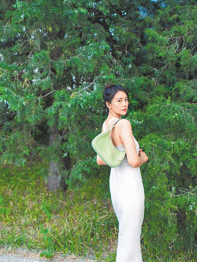 高圆圆于微博晒出街拍美照，白色修身长裙搭配鼠尾草绿MICHAEL KORS Piper腋下包。（摘自高圆圆微博）