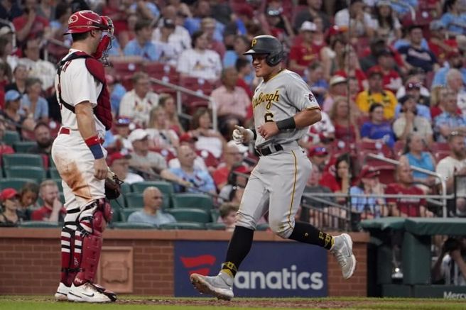 海盗队张育成(右)从红雀捕手坎尼泽面前回本垒得分。（美联社）