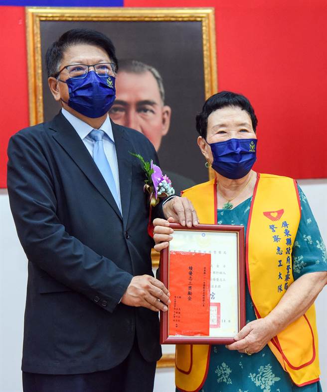 从屏东县长潘孟安（左）手上接下奖状，高龄81岁管云斌获绩优警察志工殊荣。（屏警提供／林和生屏东传真）