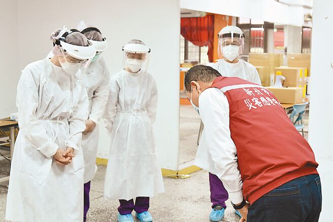 新北市长侯友宜向中和积穗社区筛检站的第一线医护人员鞠躬致意。（新北市卫生局提供／吕健豪新北传真）