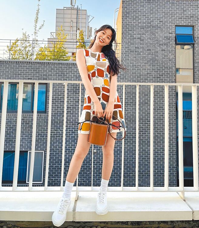 網友號稱「大勢女神」的女團偶像雪炫，一身春夏勾針拼接彩色洋裝，搭配小型Louela棕褐色水桶包，曬包之餘大露纖纖美腿。（Chloe提供）