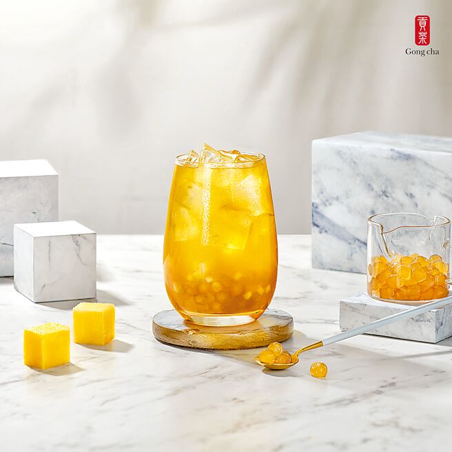 手搖飲店貢茶先前研發多款水果寶石珍珠，近期再推全新「黃金珍珠」，獨特香氣及琥珀色澤，創造新穎味覺與視覺體驗，搭「絲滑奶茶」、「鳳芒果茶」（見圖）成為今夏新品。（貢茶提供）