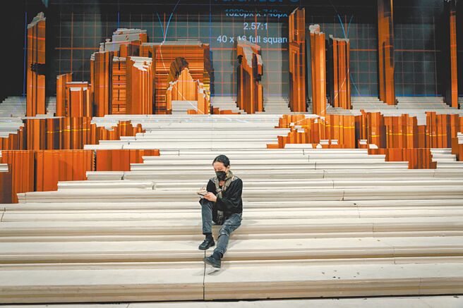 《图兰朵》排练时江青坐在空无一人的舞台上写笔记。（亚男摄影／江青提供）