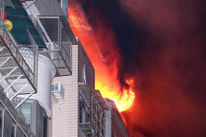 台北市吴兴街一栋6层楼的住宅发生火警，顶楼加盖处窜出火舌及阵阵浓烟，惊险景象令人怵目惊心。（黄世麒摄）