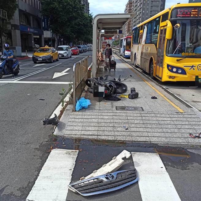 機車騎士與計程車發生事故後整輛機車衝上公車停等區。（翻攝畫面）