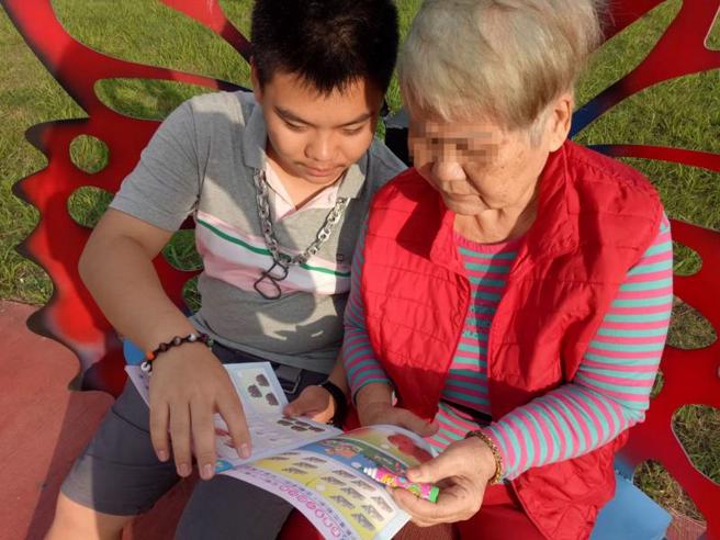 新北市政府教育局15日表示，在家自学的黄柏实（左）照顾中风的阿嬷，发挥创意透过3D列印设计辅具，让阿嬷能够训练手部肌肉进行復健，获颁新北孝行奖。（图/ 中央社）