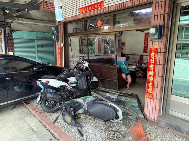 阿里山公路25.5公里處12日發生2部機車交通事故，造成3人輕傷，其中1部機車在騎士與乘客倒地後，在無人騎乘情況下，撞進路旁一處民宅，造成民宅大門損壞，停放在民宅門前1輛自小客車及2部機車也都受損。（圖/ 中央社）
