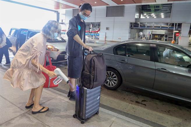 第二航厦入境层的31到33月台划设的亲友接送区，前来接机的亲友忙着用消毒喷枪帮刚下机的亲人消毒。（陈麒全摄）