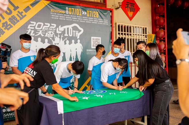 参加环台赛的「宜寧战神队」学生，在校旗上签名立誓，效仿战士出征签立「投名状」，宣示出战环台赛展示决心。（九天提供）