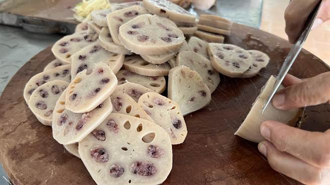 志工将糯米藏进莲藕中，经蒸煮后切片再调味。（张毓翎摄）