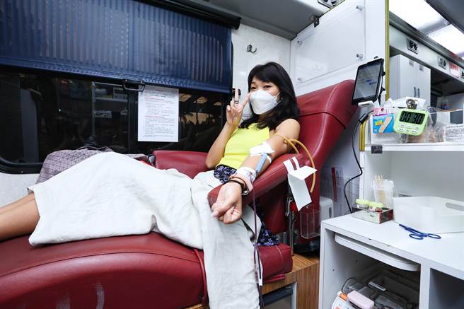 民眾利用空檔前来捐血，且开心比出胜利手势。（罗永铭摄）